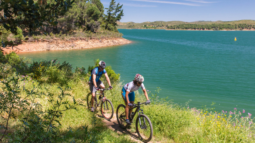 Dois ciclistas à beira-rio